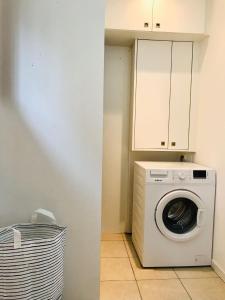 eine Waschküche mit einer Waschmaschine und einem Schrank in der Unterkunft Maison situé au centre d'Enghien les Bains avec jardin et parking privé in Enghien-les-Bains