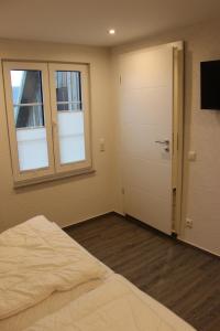 1 dormitorio con cama, puerta y ventana en Ferienhaus Kunz, en Fehmarn