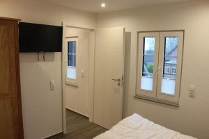 um quarto com uma cama e duas janelas em Ferienhaus Kunz em Fehmarn