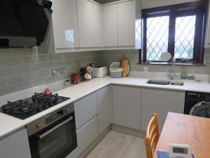 a kitchen with white counters and a stove top oven at Hillside in Llanelli