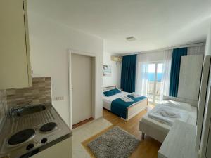 Il comprend une cuisine et une chambre avec un lit et une cuisinière. dans l'établissement Molla Apartments, à Ulcinj