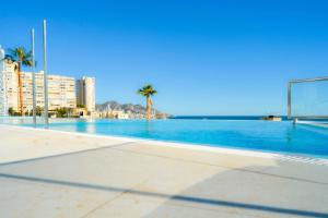 a large swimming pool with palm trees and a soccer ball at Benidorm Sunset Cliffs in Benidorm