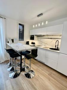 uma cozinha com armários brancos e uma mesa e cadeiras em Duplex + balcon proche centre em Grenoble