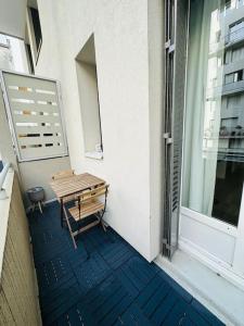um banco sentado numa varanda ao lado de uma janela em Duplex + balcon proche centre em Grenoble