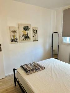 um quarto com uma cama com três fotografias na parede em Duplex + balcon proche centre em Grenoble