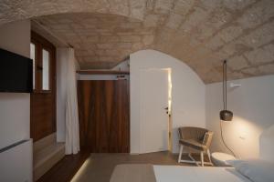 a room with a bed and a table and a chair at Palazzo Fiscaiolo in Monopoli