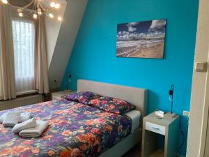 - une chambre avec un lit et un mur bleu dans l'établissement Plato by Hofstad Studio’s, à Scheveningen