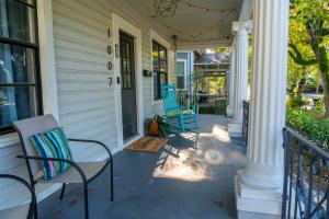 a porch with two chairs on a house at 5Beds-Walk to Bars and Shops-On Free Trolley Route in Tampa