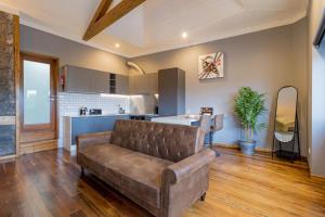 a living room with a couch and a kitchen at Canto do Atlântico Loft (City Centre) in Ponta Delgada +11 photos