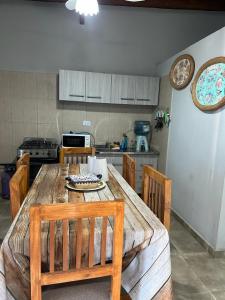 a kitchen with a wooden table and wooden chairs at Cabañas Autodromo in Termas de Río Hondo
