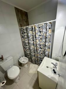 La salle de bains blanche est pourvue de toilettes et d'un lavabo. dans l'établissement Departamentos FAVE, à Esperanza