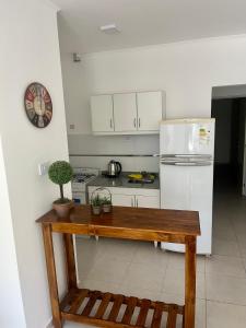 a kitchen with a white refrigerator and a wooden table at Departamentos FAVE in Esperanza