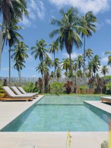 a swimming pool with palm trees in the background at Casa Salga Patacho F003 - Rota Ecológica de São Miguel dos Milagres in Pôrto de Pedras