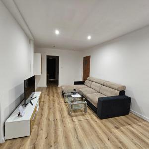 sala de estar con sofá y TV en Apartament Tuwima 1, en Prudnik