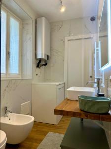 y baño blanco con lavabo, bañera y lavamanos. en The Captain's Apartments SIROCCO - CITY CENTER Leonardo Academy, en Sesto Calende