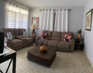 uma sala de estar com um sofá e uma mesa de centro em Marie Guest House (A/C entire house) em Camuy