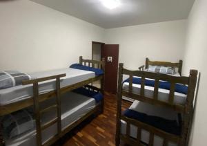 two bunk beds in a room with wooden floors at Apartamento até 8 pessoas Araxá Ótima localização in Araxá
