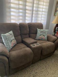 un divano marrone in soggiorno con cuscini di Marie Guest House (A/C entire house) a Camuy