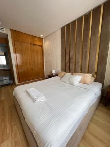 1 cama blanca grande en una habitación con paredes de madera. en Luxury appartement in Heart of Casablanca Maarif en Casablanca