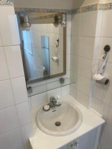 a white bathroom with a sink and a mirror at Paris Centre Place Saint Michel in Paris