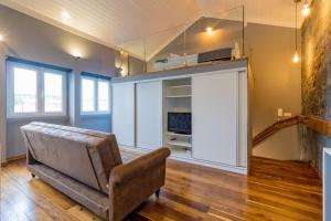 ein Wohnzimmer mit Sessel und Couch in der Unterkunft Canto do Atlântico Loft (City Centre) in Ponta Delgada