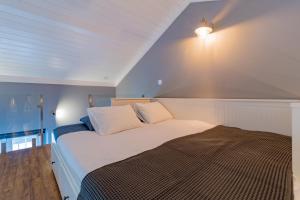 ein Schlafzimmer mit einem großen Bett mit einer Lampe an der Wand in der Unterkunft Canto do Atlântico Loft (City Centre) in Ponta Delgada + 9 Fotos