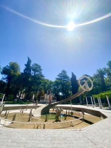 einen Park mit einem Brunnen mit der Sonne am Himmel in der Unterkunft Habitación En España 1512 in Mendoza