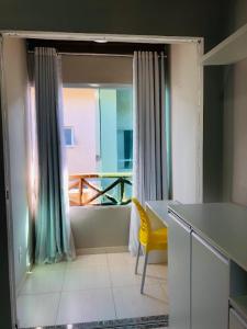 una cucina con finestra, tavolo e sedia gialla di Casa e Conforto na Praia de Imbassaí a Imbassai Altre 75 foto