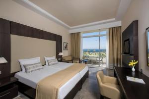 a hotel room with a large bed and a desk at Iberostar Selection Diar El Andalous in Port El Kantaoui