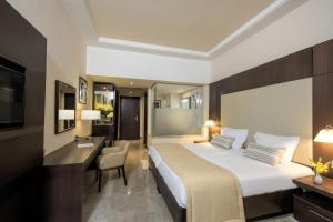 a hotel room with a large bed and a desk at Iberostar Selection Diar El Andalous in Port El Kantaoui