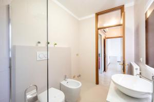 a white bathroom with a sink and a toilet at Beccaria17 in Parma +12 photos