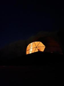 a glass dome lit up at night at Moon Magic Valley in Wadi Rum