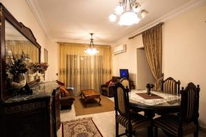a living room with a dining room table and a couch at Cozy apartment in Sheikh Zayed, with private garden in 6th Of October