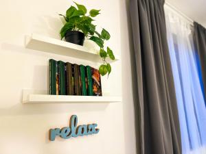 une étagère avec des livres et une plante en pot dans l'établissement Rooms Koblar, à Portorož