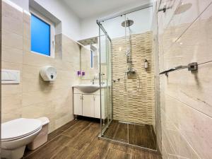 La salle de bains est pourvue d'une douche, de toilettes et d'un lavabo. dans l'établissement Rooms Koblar, à Portorož