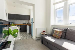 a living room with a couch and a kitchen at ST MARYS APARTMENT - Modern Apartment in Charming Market Town in the Peak District in Penistone