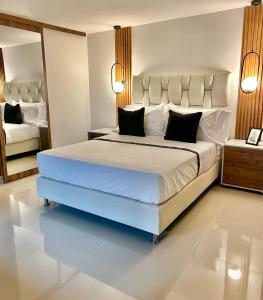 a bedroom with a large white bed with black pillows at Naiot Hotel Boutique in Medellín