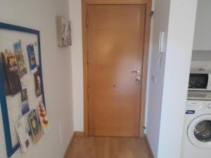 a wooden door in a room with a washing machine at IM80 in Montroig