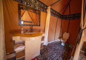 a bathroom with a sink and a toilet in a tent at Shiny luxury camp in Merzouga