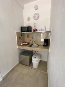 eine kleine Küche mit einer Theke und einem Waschbecken in der Unterkunft Casa Coronaa Holbox México in Holbox
