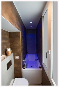 ein Badezimmer mit einer lila Badewanne und einem WC in der Unterkunft Xenia Neapolis in Neapel