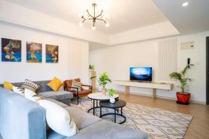 a living room with a couch and a tv at Laurel Hill Suites in Nairobi