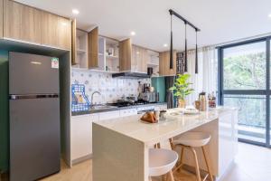 a kitchen with a refrigerator and a counter with stools at Laurel Hill Suites in Nairobi