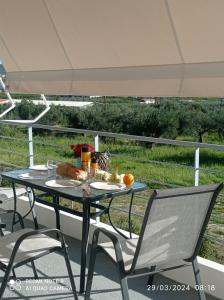 einen Tisch und Stühle auf einer Terrasse mit Sonnenschirm in der Unterkunft Ikiesnafplio in Nafplio
