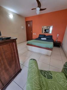 um quarto com uma cama e um sofá em Pousada Zênit Peró II em Cabo Frio