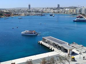 a boat is docked at a dock in a harbor at Seafront Duplex Penthouse in Sliema