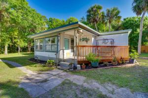 a tiny house with a front porch and trees at Cozy Fort Pierce Cottage on Farm Animal Rescue! in Fort Pierce