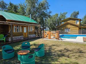 einen Hof mit Hockern, ein Haus und einen Pool in der Unterkunft Sommerwind Cabañas in La Estancia