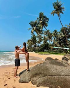 um homem e uma mulher de pé numa praia em Neem Tree Ambalangoda em Ambalangoda
