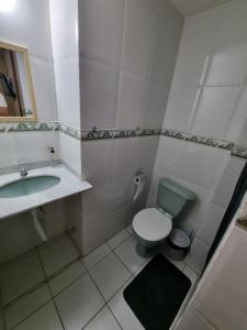 a bathroom with a green toilet and a sink at Pousada Zênit Peró II in Cabo Frio